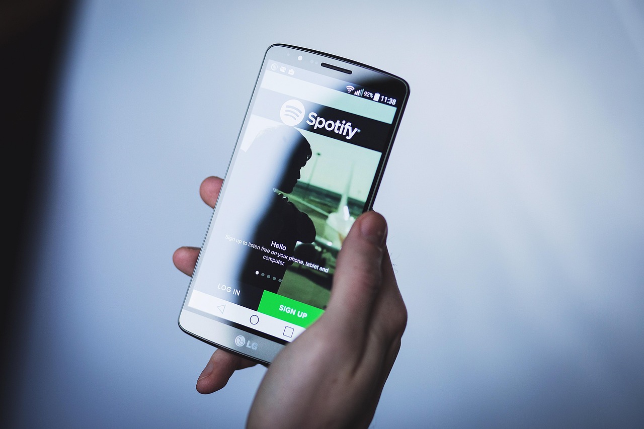 Mano sosteniendo un teléfono celular con la aplicación de Spotify abierta